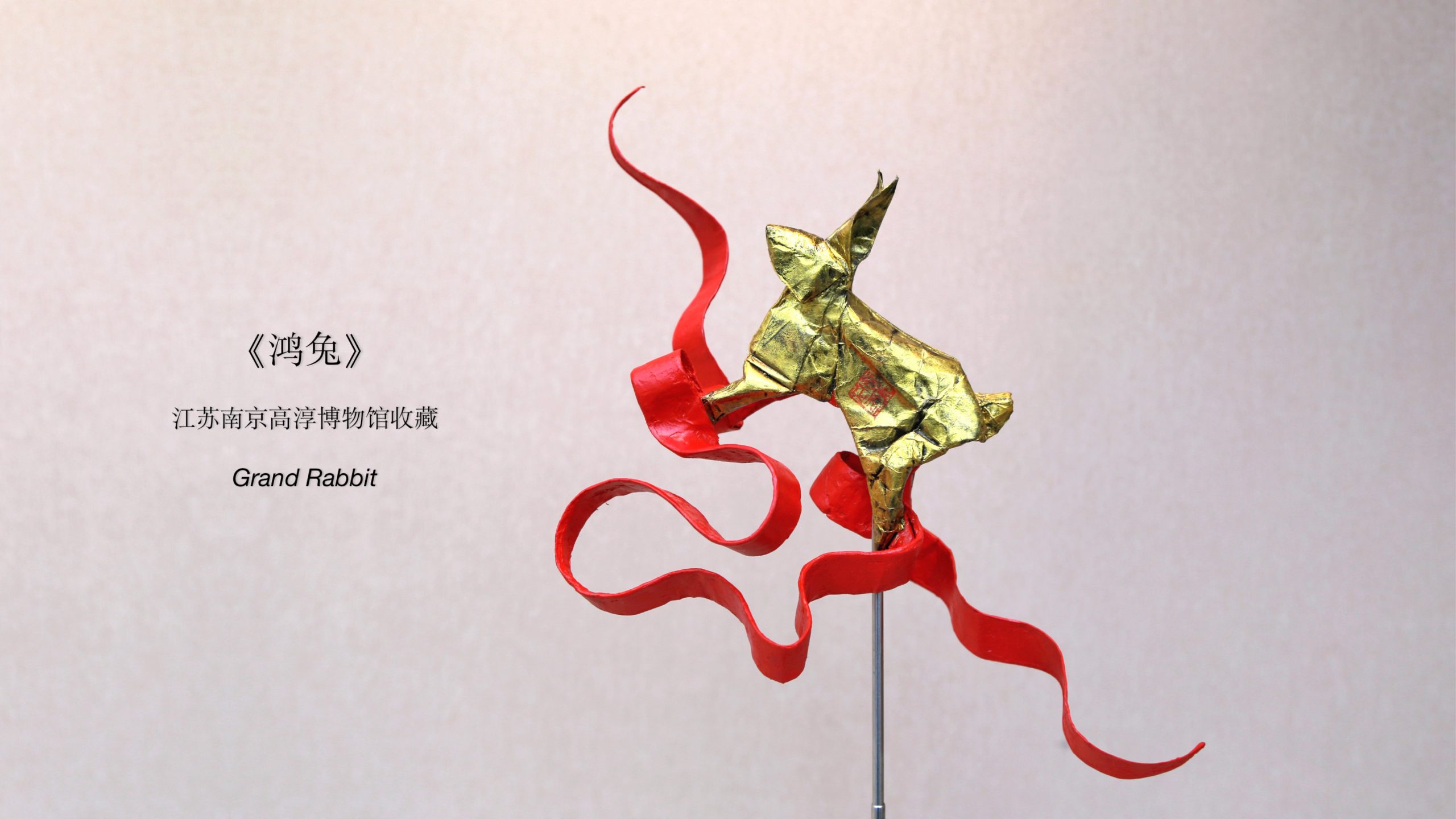 붉은 띠와 함께 표현된 금색 토끼 종이접기 작품 Grand Rabbit